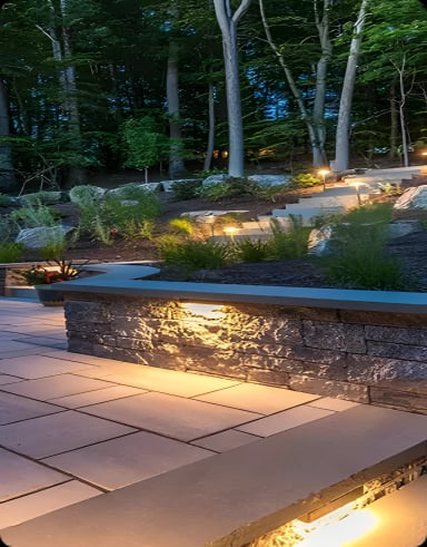 Beautifully landscaped outdoor space at dusk with lighting